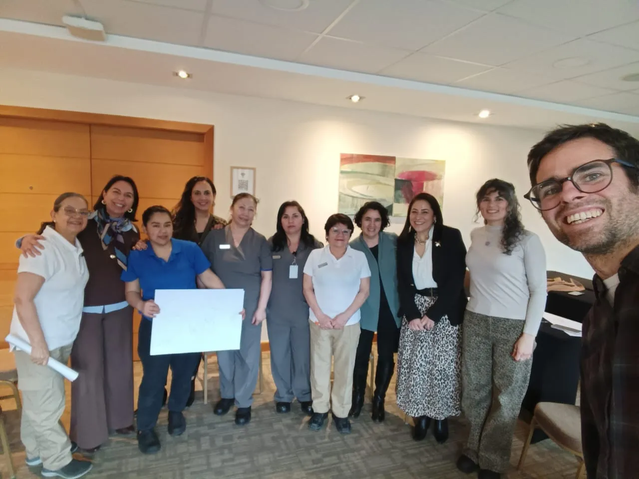 El equipo del Wyndham Petra posa de pie en una sala del hotel junto a Ignacio; una de las participantes sostiene una hoja grande con su dibujo.